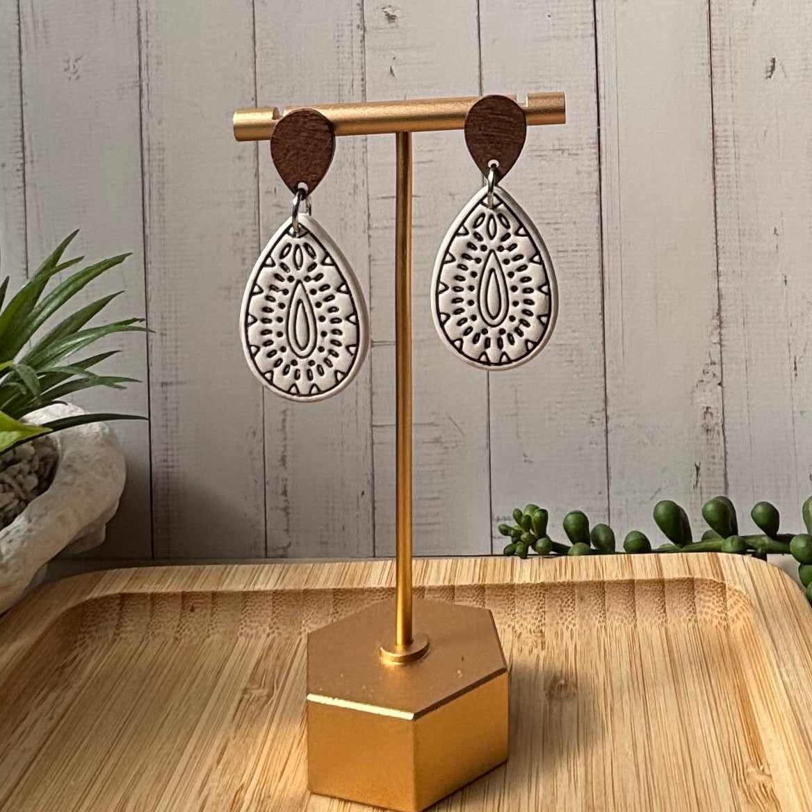 Polymer clay teardrop dangle earrings with intricate black inlay patterns and dark brown wooden top accents, by little Lis studio. 